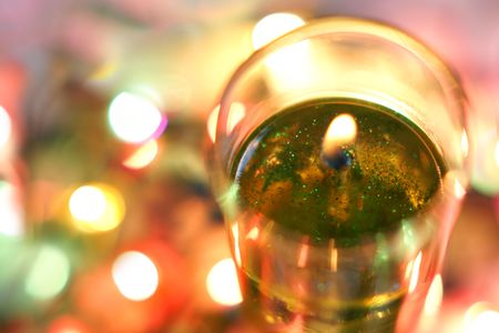 Flame of candle, garland lights in the backgroundの写真素材