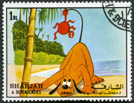SHARJAH & DEPENDENCIES - CIRCA 1972: A stamp printed by Sharjah & Dependencies devoted fifty years of Walt Disney cartoon characters, shows Pluto, series, circa 1972のeditorial素材