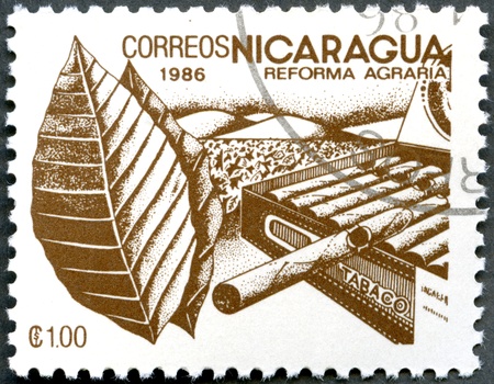 NICARAGUA - CIRCA 1986: A stamp printed in Nicaragua shows image of agrarian reform, Tobacco, circa 1986の写真素材