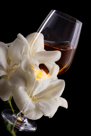 Double exposure of glass of wine over white freesia, a vertical pictureの写真素材