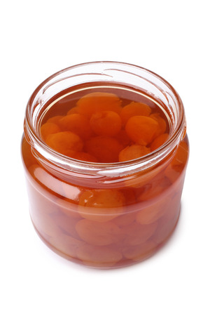 Yellow cherry jam in glass jar on white backgroundの写真素材