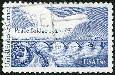 UNITED STATES OF AMERICA - CIRCA 1977: A stamp printed in USA shows Peace Bridge and Dove, dedicated to the 50th anniversary of the Peace Bridge, connecting Buffalo, NY with Fort Erie, Ontario, circa 1977のeditorial素材
