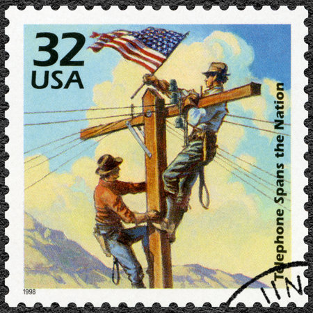 UNITED STATES OF AMERICA - CIRCA 1998: A stamp printed in USA shows First transcontinental telephone line, 1914, series Celebrate the Century, 1910s, circa 1998のeditorial素材