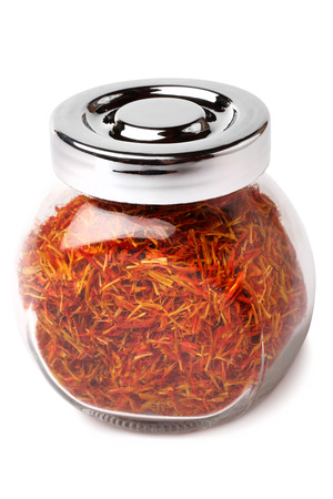 Saffron spice in glass jar on white backgroundの写真素材