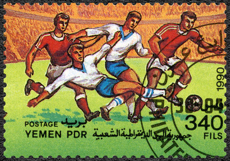 YEMEN PDR - CIRCA 1990: A stamp printed in Yemen PDR shows Soccer game, History of World Football Championships, circa 1990のeditorial素材