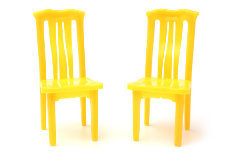 Yellow plastic chairs on white backgroundの写真素材