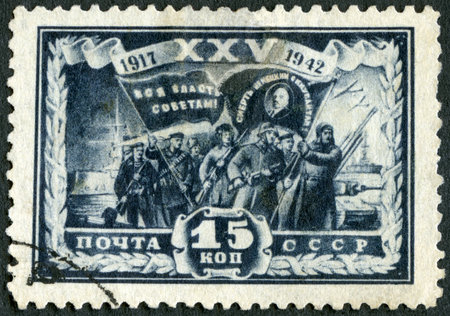 USSR - CIRCA 1942: A stamp printed in USSR shows Group of  Fighters, series Revolution scene, 25 anniversary, circa 1942のeditorial素材