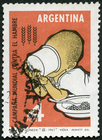 ARGENTINA - CIRCA 1963: A stamp printed in Argentina shows Child Draining Cup, FAO Freedom from Hunger campaign, circa 1963のeditorial素材