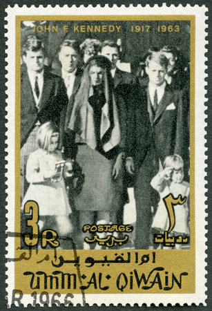 UMM AL-QUWAIN - CIRCA 1965: A stamp printed in Umm al-Quwain shows Kennedy family on steps of St. Matthew's Cathedral, Jacqueline Lee Jackie Bouvier Kennedy (1929-1994), John F. Kennedy (1917-1963), circa 1965のeditorial素材