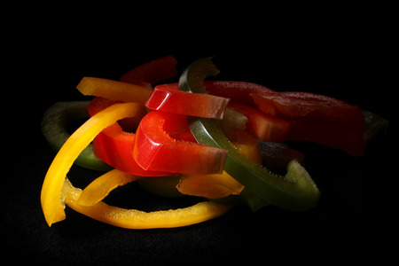 Color slices of bulgarian pepper on black background