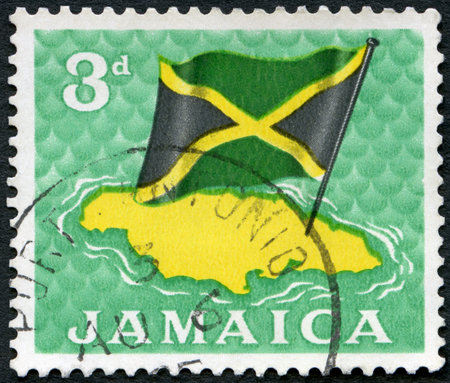 JAMAICA - CIRCA 1964: A stamp printed in Jamaica shows Flag over map, circa 1964のeditorial素材