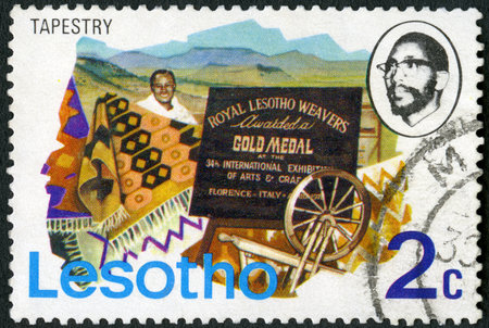 LESOTHO - CIRCA 1976: A stamp printed in Lesotho shows Tapestry form of textile art, weavers and citation, circa 1976のeditorial素材