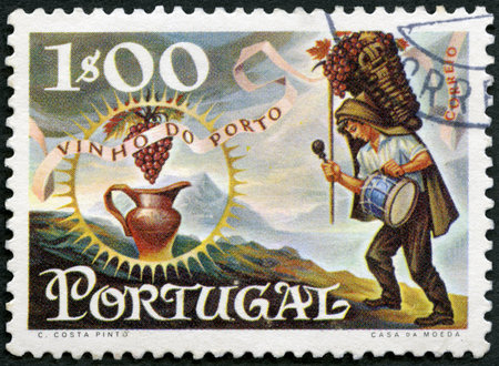 PORTUGAL - CIRCA 1970: A stamp printed in Portugal shows Worker carrying basket of grapes and jug, series Publicity for port wine export, circa 1970のeditorial素材
