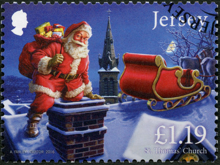 JERSEY - CIRCA 2016: A stamp printed in Jersey shows Father Christmas in Jersey, On the roof, St Thomas Church, circa 2016のeditorial素材