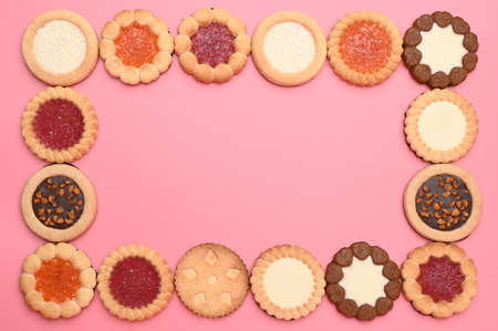 Frame made of different cookies on pink backgroundの写真素材