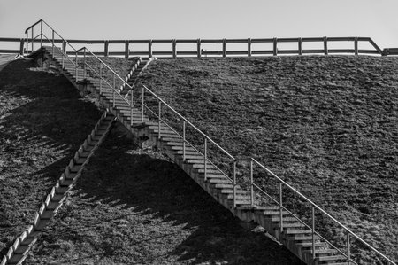 View of concrete stairs and modules for draining excess water from the road surface on the slope of the highway. Black-and-white photoの写真素材