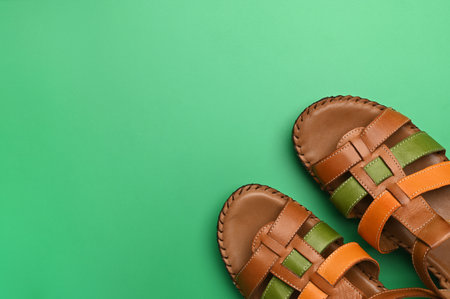 Pair of woman's summer sandals on green backgroundの写真素材