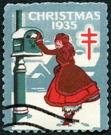 UNITED STATES OF AMERICA - CIRCA 1935: A stamp printed in USA shows Girl sends letter, devoted Christmas, circa 1935の写真素材