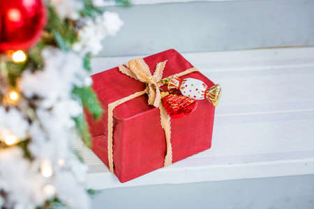 Christmas gift box. Christmas present in red box at white wooden table.の写真素材
