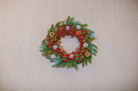 Christmas wreath handmade on a wooden background. New Year's interior decoration