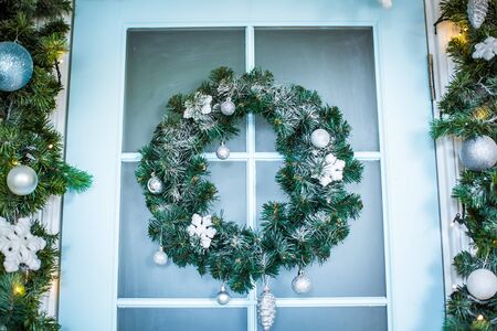Christmas wreath with baubles, cones and evergreen boughs on a blue door.の写真素材