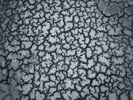 Dark cracked clay ground, drought land background                                 