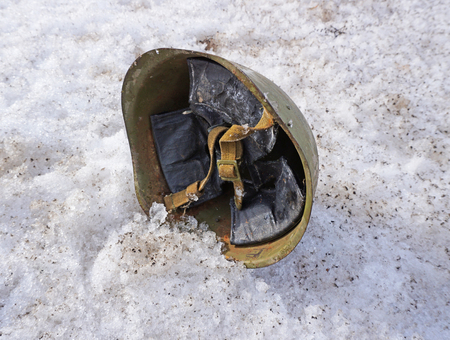 soldier's helmet lying on the snow in the afternoonの写真素材