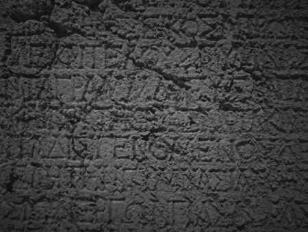 Ancient greek inscription carved in dark marbleの写真素材