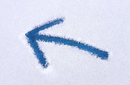 Blue arrow pointing left drawn into snow.