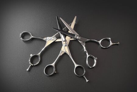 hairdressing different scissors isolated on black background. Hairdressing  scissors equipment on...