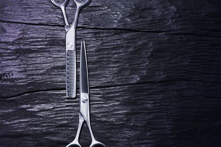 hairdressing different scissors isolated on dark wooden  background.の写真素材