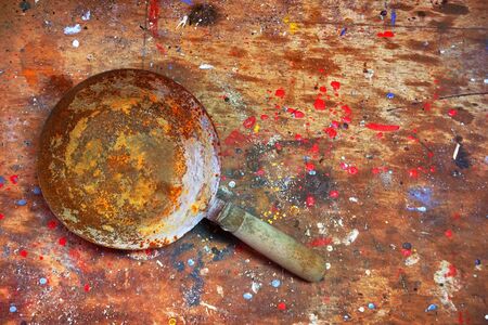 Old used hand bucket for trowel isolated on wooden background