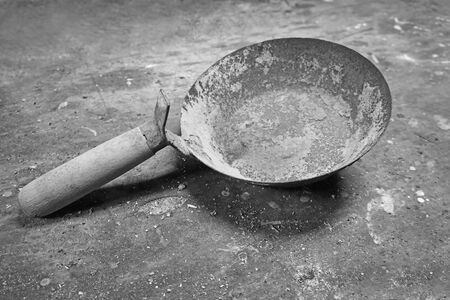 Old used hand bucket for trowel isolated on wooden backgroundの写真素材