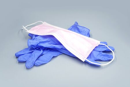 Medical mask and gloves. Grey background                               