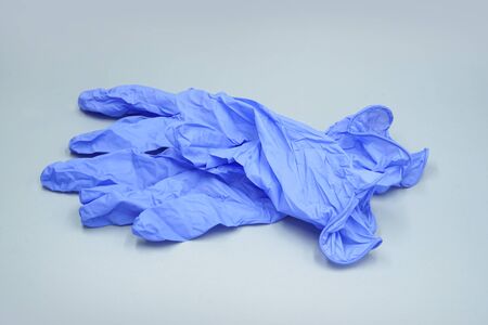Two medical gloves on a grey background. Medical glove for protection and patient care              ...