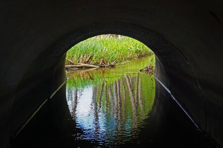 Water drainage channel. Light at End of Round Tunnel.の写真素材