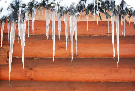 Small icicles on a wooden background. Template for an inscription. Mockup for design