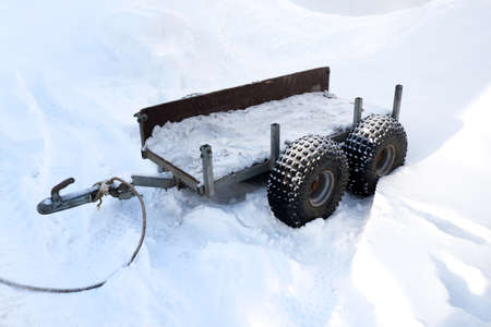 a large cart on wheels stands in the snow in winter