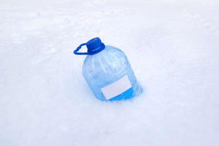 a plastic canister for car windows lies in the snowの写真素材