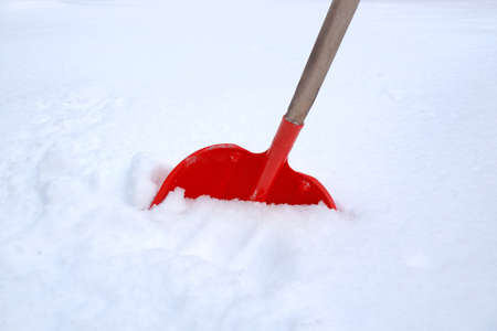a shovel for snow removal stands in a snowdriftの写真素材