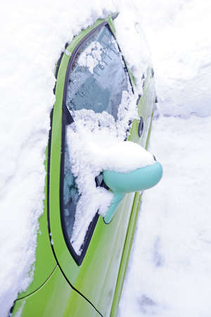a car in the snow. car mirror close-up in the snowdrift after blizzard.の写真素材