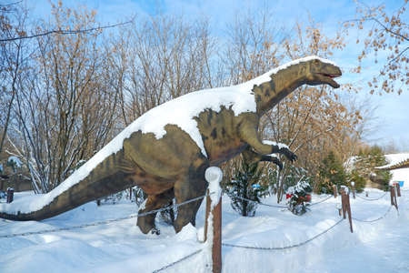 lifesize reconstruction of a giant dinosaur in the winter parkの写真素材
