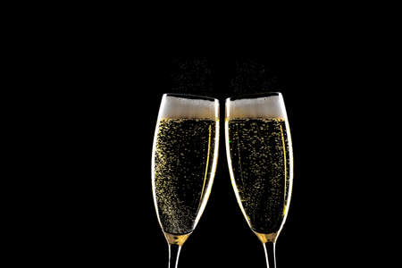 Two glasses of champagne with spray above over black backgroundの写真素材