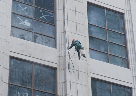 A worker is washing the building located in shanghaiのeditorial素材