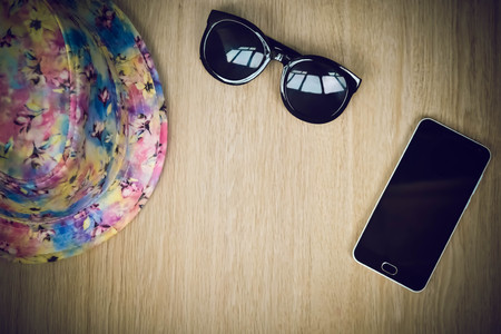 Top view of holiday items, hat, glasses and phoneの写真素材