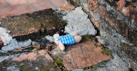 An abandoned headless doll laying on the bricked floor.の写真素材