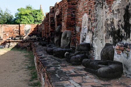 The headless Buddha statues sitting on the pedestal in the backside of Wat Mahathat. The reflection of ritual, pray and meditation.の写真素材