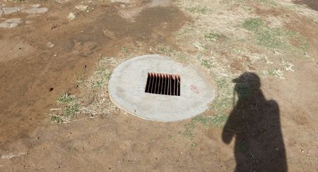 A shadow of strange photographer while photographing a drain hole. Yes, it's my shadow.の写真素材
