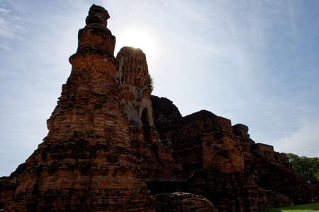 A photo of temple within Wat Mahathat area with a golden sunlight on the tip of the stupa.の写真素材