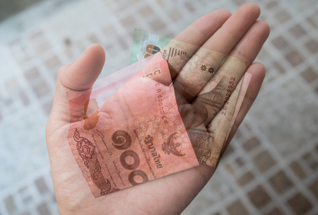 A hand holding Thai Baht bank notes. Added faded effect on the bank notes.の写真素材